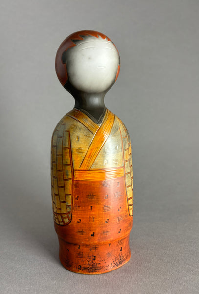 Kokeshi garçon tête rouge, kimono orange en haut, rouge en bas