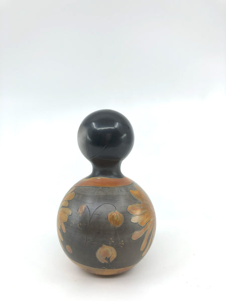 Kokeshi boule gris mat, grande fleur orange brillante.