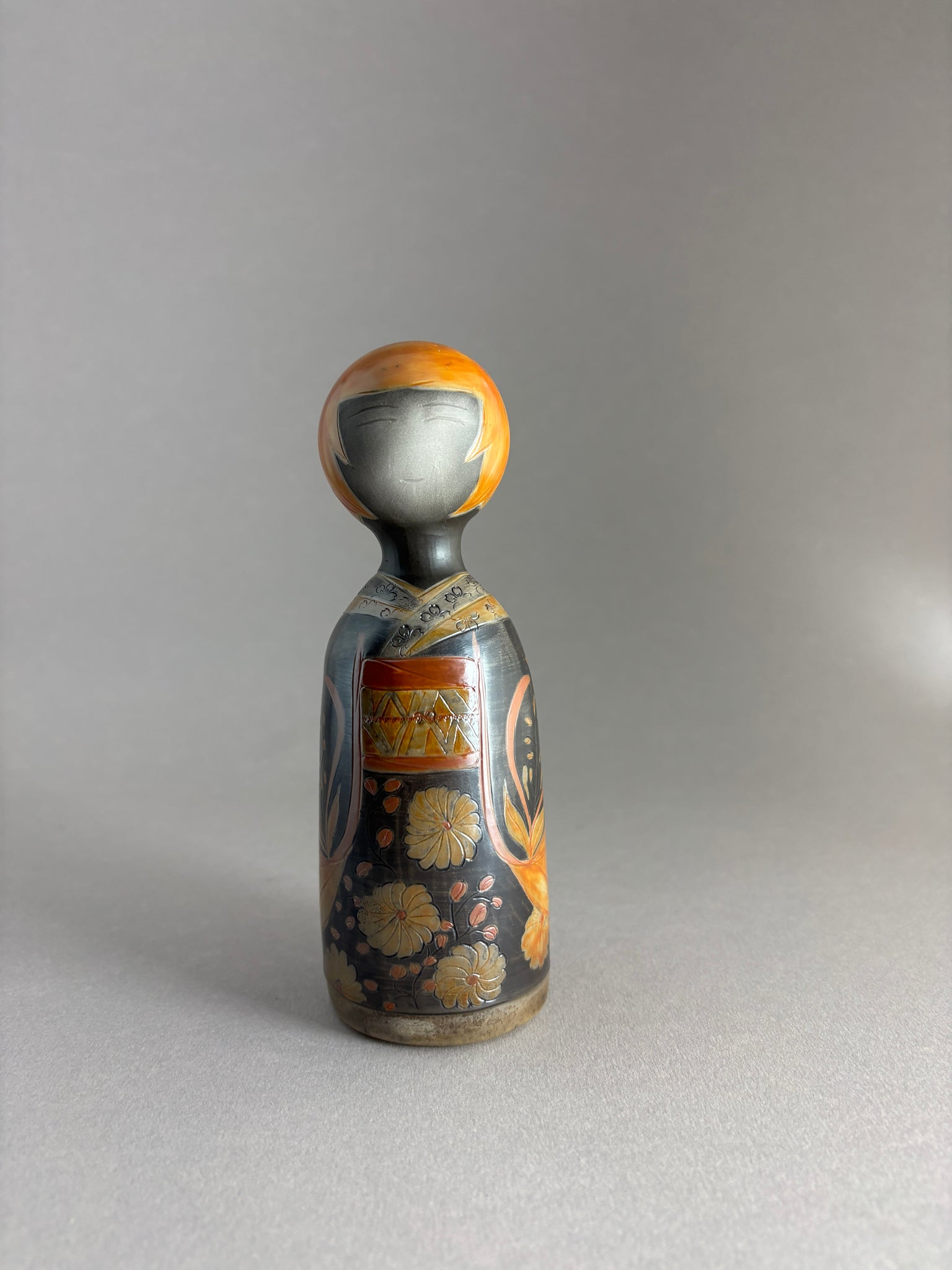 Kokeshi kimono foncé, tête orange petites mèches.