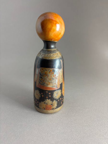 Kokeshi kimono foncé, tête orange petites mèches.