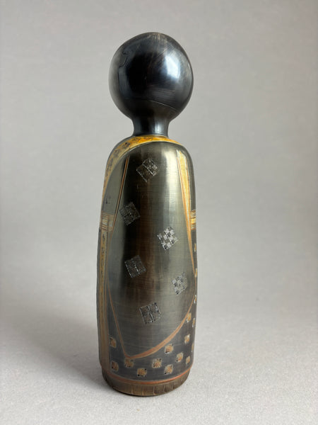 Kokeshi garçon kimono foncé petit motif répété donnant matière