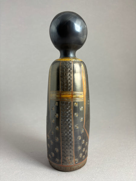 Kokeshi garçon kimono foncé petit motif répété donnant matière