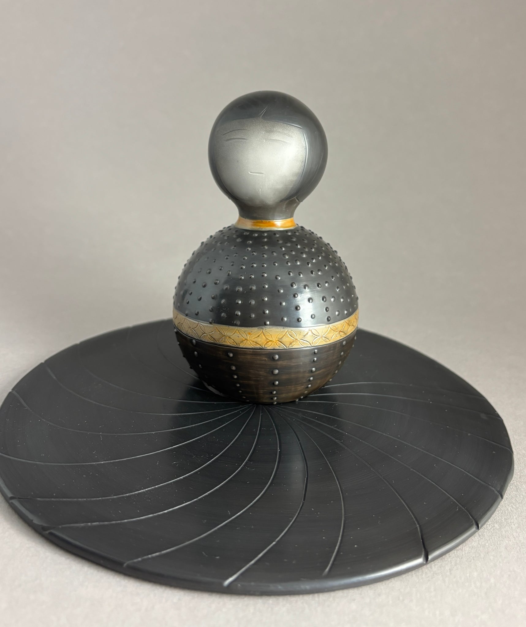 Kokeshi boule foncée pois relief sur socle plat